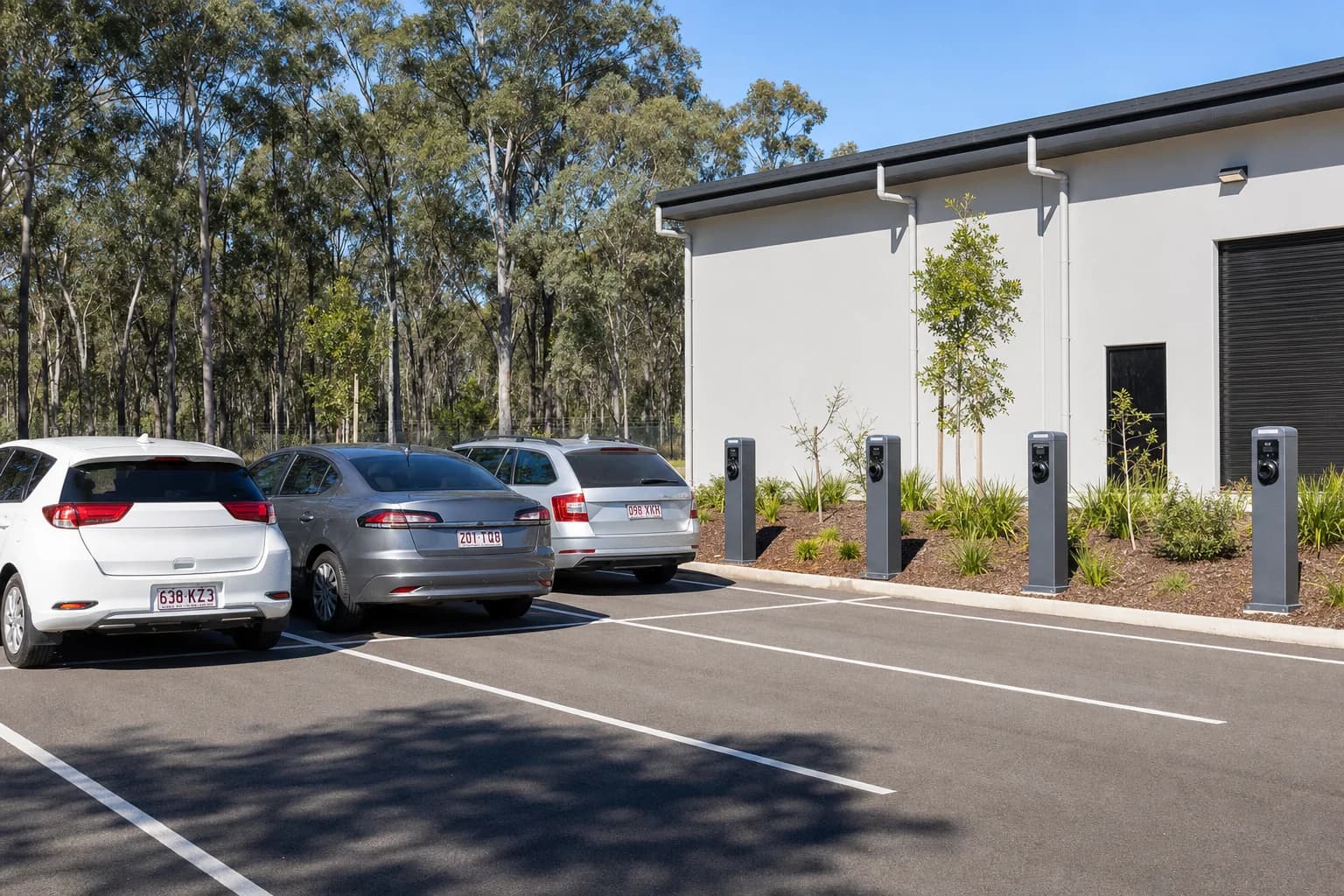 A row of electric vehicle charging bollards in a commercial car park
